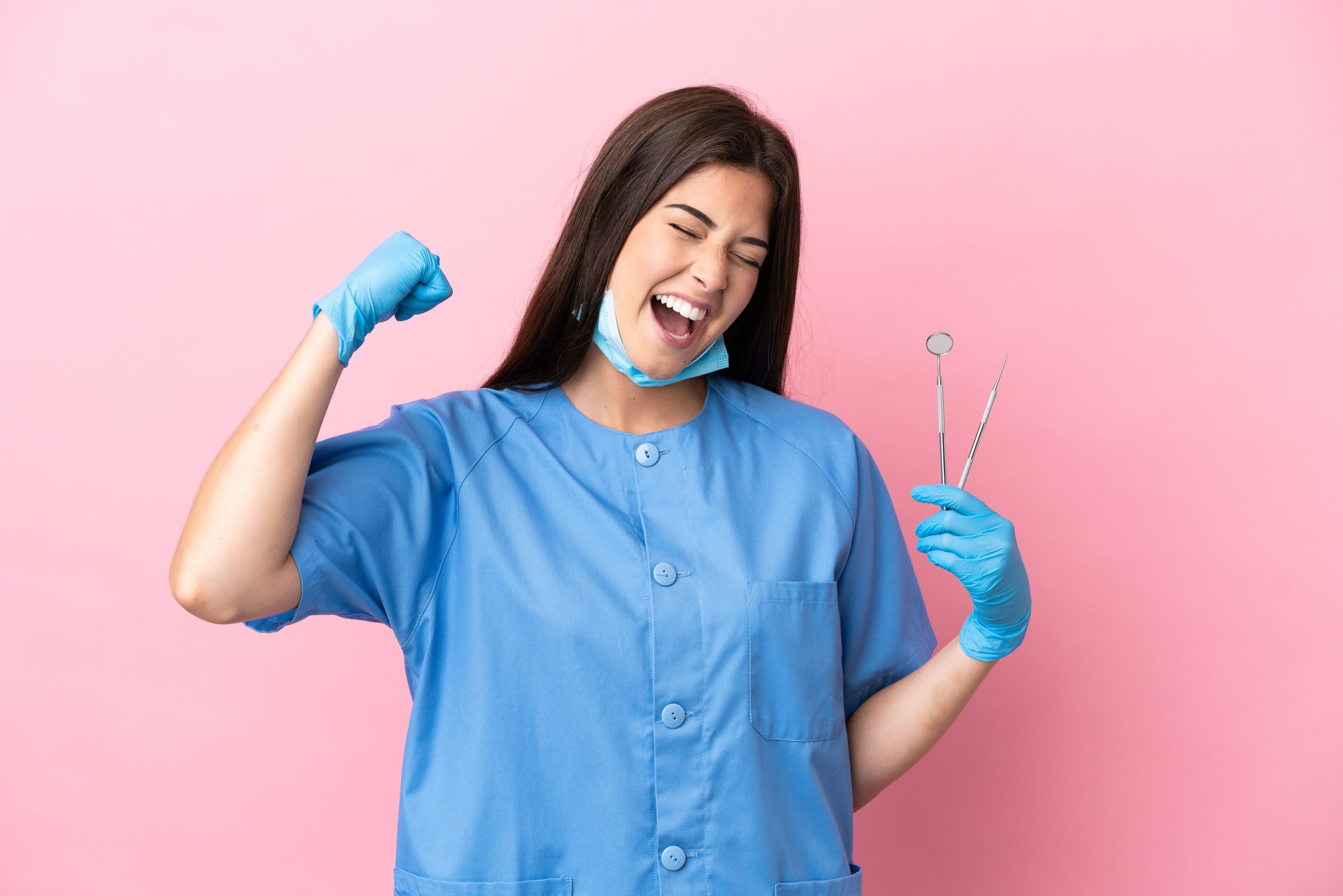 Dentist Woman Holding Tools Isolated On Pink Background Celebrating A Victory