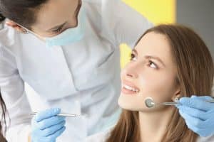 Restorative and cosmetic dentistry is expensive and often not covered by dental insurance. Many people don't get the dental treatment they need because they can't afford it. Contact Lee Family Dentistry for restorative dentistry. Image of smiling patient and dental assistant with tools in hands.