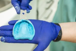 If you're looking for a more gentle, compassionate experience with your dental care, Lee Family Dentistry is the right choice. We use cutting-edge technology and highly-trained dentists to give you the best possible service. Image of dentist holding a dental impression in gloved hands.